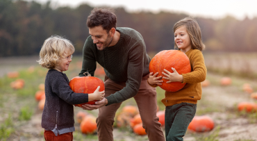 Man with boy and girl in pumpkin patch